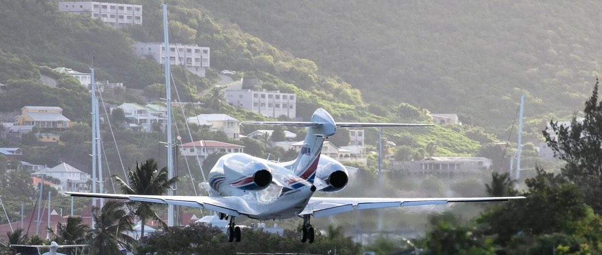 Cessna Citation X arriving over a Caribbean hillside, private jet charter services
